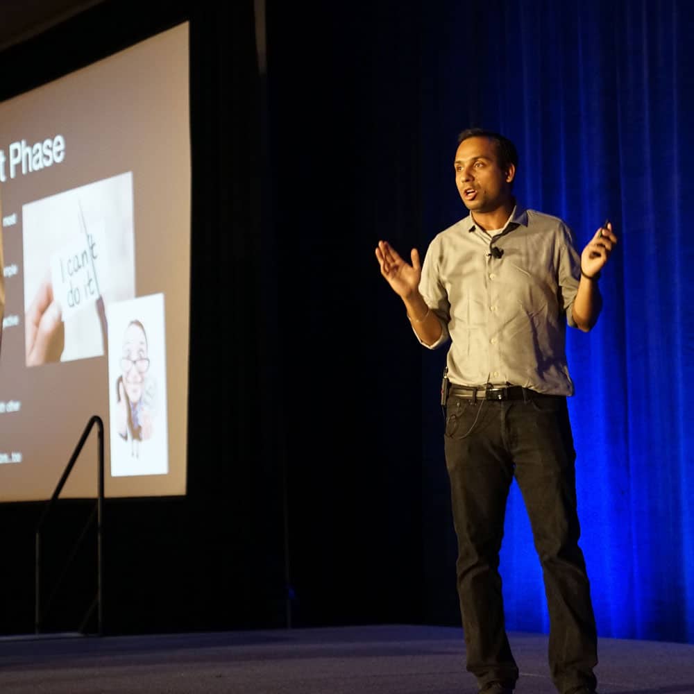 A man standing on stage doing a presentation