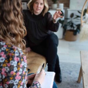 Two women discussing content marketing strategy one facing the camera and gesturing with hands